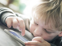 Little boy playing on a smart phone